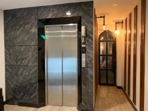 a elevator in a hallway with black marble walls at Orasa hotel in Mae Sai