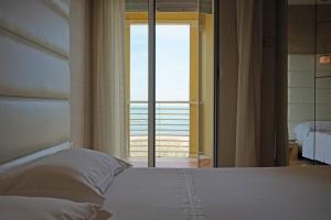 a bedroom with a bed with a view of the ocean at AmbientHotels Panoramic in Rimini