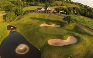 an aerial view of a golf course with a house at The Manor House At Celtic Manor in Newport