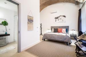 a bedroom with a bed and a door leading to a bathroom at Urban Stable Luxury Apartments in Budapest