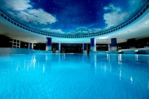 - une piscine la nuit avec les étoiles au plafond dans l'établissement The Manor House At Celtic Manor, à Newport