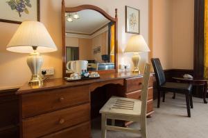 a bedroom with a desk with a mirror and a chair at Adelphi Hotel in Liverpool