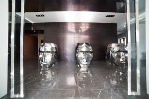 3 sedie d'argento su un pavimento piastrellato nella hall di Al Boschetto a Castel Volturno