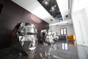 a lobby with two metal sculptures on a marble floor at Hotel Art Al Boschetto in Castel Volturno