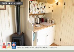 a small kitchen with a stove in a room at Morndyke Shepherds Huts in Thirsk