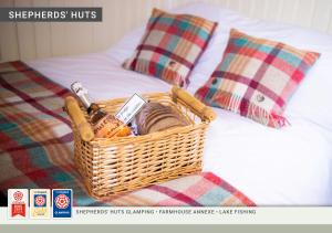 a wicker basket sitting on a bed with pillows at Morndyke Shepherds Huts in Thirsk