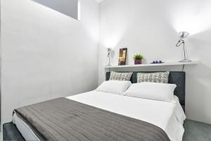 - une chambre avec un grand lit aux murs blancs dans l'établissement MStudio / Loft, à Lecce