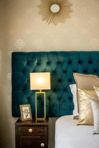 a bed with a blue headboard and a lamp on a table at Gaze out at the City in a Retro-Chic Getaway in Lisbon