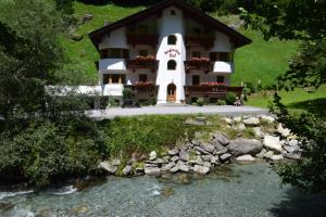 une maison avec une rivière devant elle dans l'établissement Steglacher Hof, à Mayrhofen