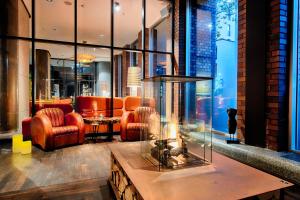 a lobby with a living room with orange furniture at ACHAT Hotel Bremen City in Bremen