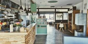 a coffee shop with a counter and a table at Moselsteig Lodge in Starkenburg +56 photos