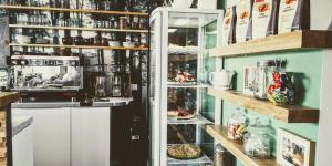 a kitchen with a refrigerator and shelves with food at Moselsteig Lodge in Starkenburg