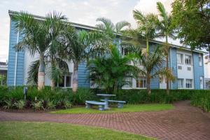 a blue building with a picnic table in front of it at Premier Splendid Inn Bayshore in Richards Bay