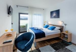 a bedroom with a bed and a chair and a desk at Villa Lu-Ma Beachfront with Heated Pool in Turanj