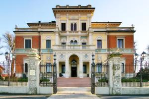 een oud huis met een hek ervoor bij Hotel Villa Borghesi in Corte dei Cortesi