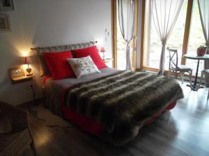 Le NoyerにあるLa Buissonnièreのベッドルーム1室(大型ベッド1台、赤い枕付)