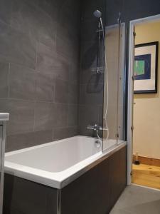 a bathroom with a bath tub with a shower at Gabe's Rooms in Central London in London