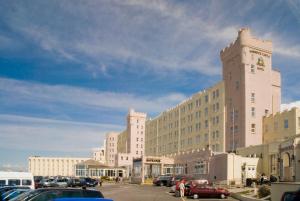 een groot gebouw met auto's geparkeerd op een parkeerplaats bij Norbreck Castle Hotel & Spa in Blackpool