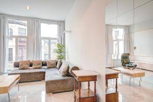 a living room with a couch and some windows at Three Bedroom Marble Apartment in the Heart of Antwerp in Antwerp