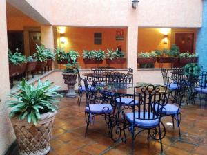 a dining room with tables and chairs and potted plants at Hotel La Rienda Mision Tequillan in Tequila