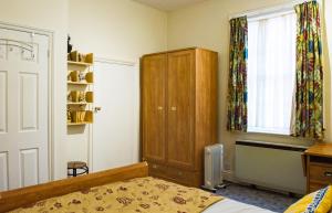 una camera da letto con un letto, un armadio e una finestra di Town Centre Apartment a Leamington Spa