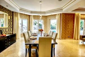 a dining room with a table and chairs and windows at Villa SVIM, walking distance to the beach! in Marbella