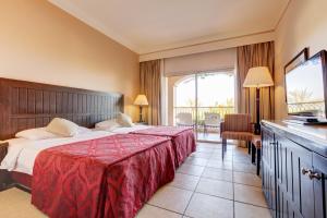 um quarto de hotel com uma cama com um cobertor vermelho em TUI MAGIC LIFE Kalawy em Hurghada