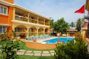 a hotel with a swimming pool in front of a building at Martins Comfort in Betalbatim