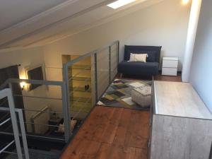 uma sala de estar com uma escada e um sofá em 3t House em Cremona