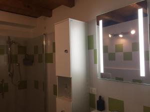 y baño con ducha y espejo. en 3t House en Cremona