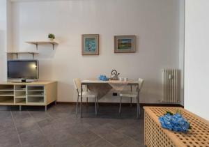 sala de estar con mesa y TV en Galleria Roma Apartment - Affitti Brevi Italia, en Lecco