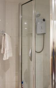 a shower with a glass door in a bathroom at Town Centre Apartment in Leamington Spa