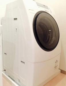 a white washing machine sitting on top of a cabinet at 光アパートメント広島駅前 HIKARI Apartment Hiroshima Station in Hiroshima