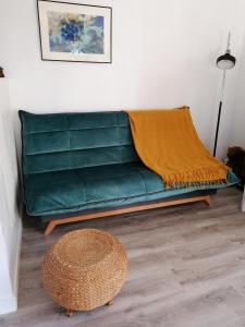 a green couch in a living room with a table at Le Grenier de Gaston in Thouars-sur-Garonne