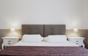 1 dormitorio con 1 cama grande y 2 mesitas de noche blancas en CasaMamy Pompei, en Pompeya
