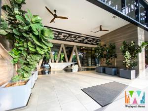 a lobby with potted plants in a building at KLCC View Expressionz Family Loft by WGS in Kuala Lumpur