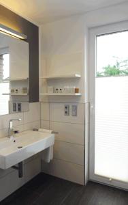 a white bathroom with a sink and a window at Hotel Am Markt in Heek