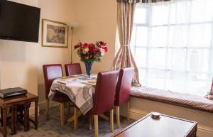 uma sala de jantar com uma mesa e cadeiras e uma janela em Town Centre Apartment em Leamington Spa