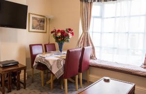 a dining room with a table and chairs and a window at Town Centre Apartment in Leamington Spa