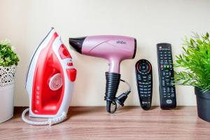 a pink hair dryer next to a phone and a remote control at Hotel Provans in Moscow