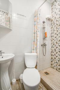 a white bathroom with a toilet and a shower at Hotel Provans in Moscow