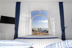 a bedroom with a bed and a window with a view at Palazzo San Giovanni Amalfi Coast in Scala