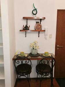 a table with two chairs and a vase with flowers at Acogedor y Elegante Estudio cerca al Prado in Cochabamba