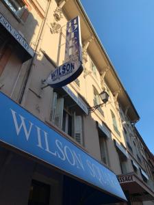 a building with a sign for a wisconsin street at Hotel Wilson Square in Toulouse