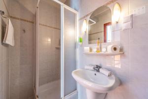 a white bathroom with a sink and a shower at Korona Panzió Budapest in Budapest +47 photos