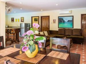 a living room with a couch and a table with flowers at VIEWBOR VILLA - PATTAYA HOLIDAY HOUSE WALKING STREET 4 bedrooms in Pattaya South