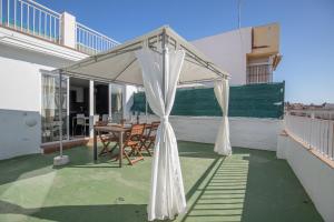 eine Terrasse mit weißem Baldachin auf dem Dach in der Unterkunft HOMEABOUT LA MERCED Duplexes in Málaga