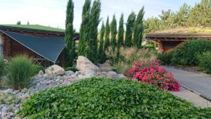 un jardín con rocas y plantas y una casa en Les Chalets de Maramour, en Chazey-sur-Ain