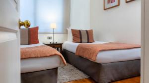 two beds sitting next to each other in a room at Suite Comfort Apartments by Time Hotel & Apartments in Santiago
