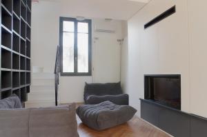 a living room with a couch and a television at L'Echoppe - Maison 3 chambres avec 2 salles de bain et grande Terrasse in Talence